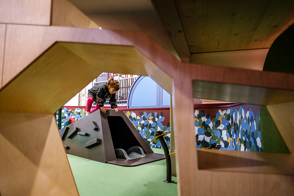 Ein Kind tobt sich auf einem Baugerüst im Museum aus. 
